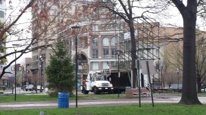 City truck is parked in front of scaffolding structure with workers preparing to hang banners...and later moved, rather than remaining parked to hang three banners, to hang FFRF banner on reverse side of scaffolding